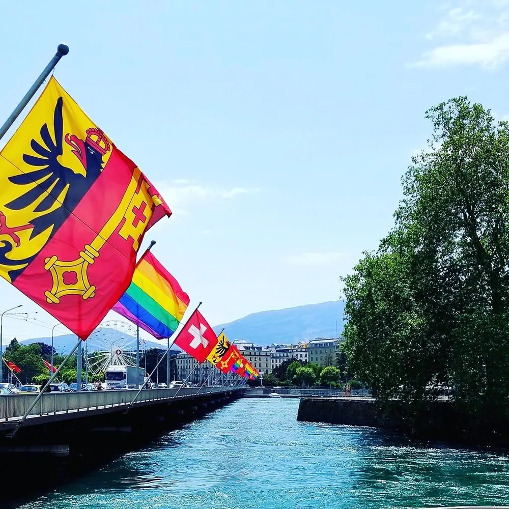 Flags along a Geneva bridge over the Rhone on a summer day